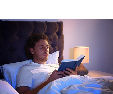 Afbeelding van een jonge man die in bed ligt en een boek aan het lezen is
